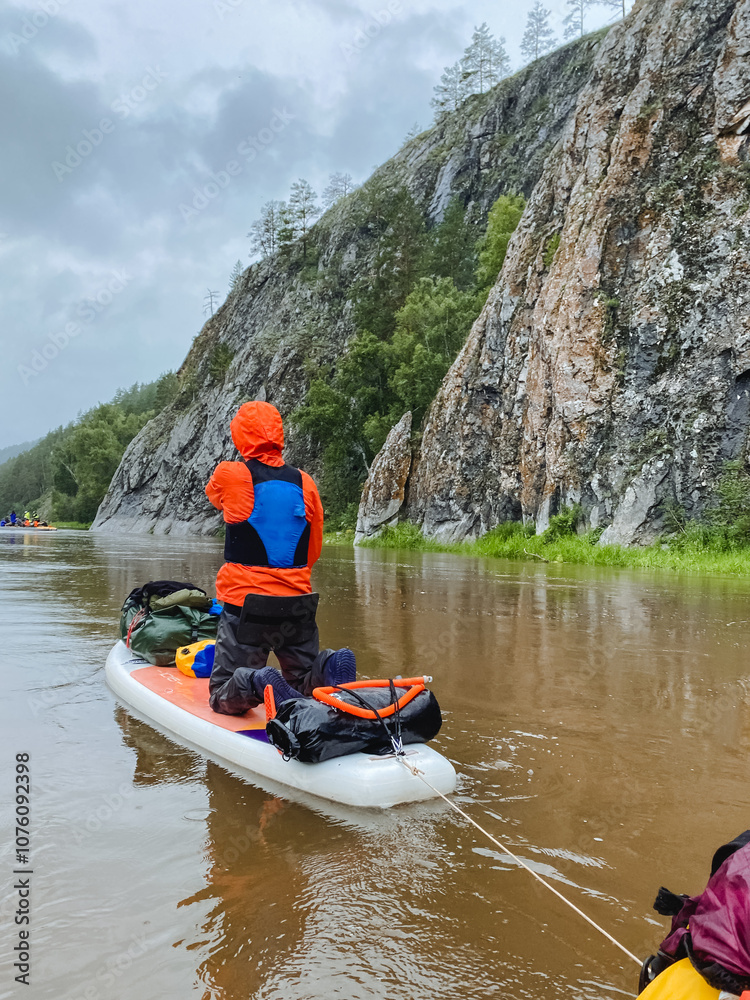 A man is leisurely pulling a kayak down a calm river, fully enjoying a tranquil day on the serene lake while also finding a deep connection with the beauty of nature surrounding him