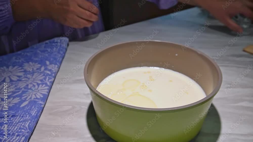 Hands preparing dough in kitchen with yellow mixing bowl and flour tablecloth Hands preparing dough in kitchen with yellow mixing bowl and flour tablecloth