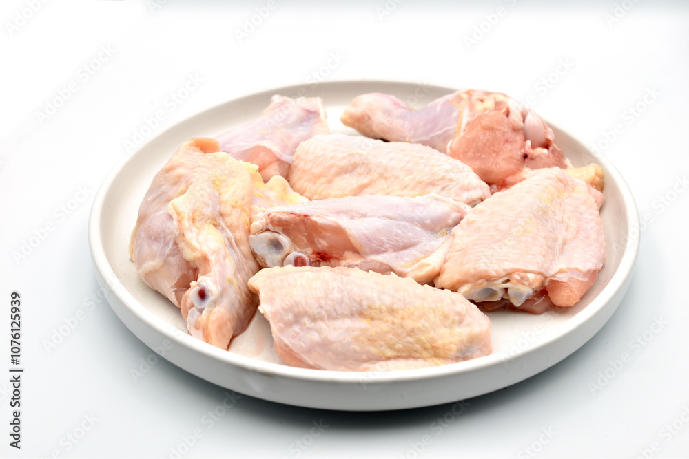 Chicken meat lies on a clay plate, which stands on a white background. Chicken meat lies on a clay plate, which stands on a white background.