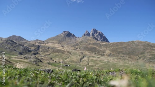 Pic du Midi d Ossau, french Pyrenes with a clear blue sky in the background. The mountains are covered in grass