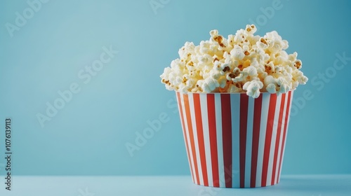 Popcorn in a bucket on a blue background creates a vibrant scene, perfect for capturing the essence of popcorn. This image highlights popcorn arranged in a bucket with ample copy space.