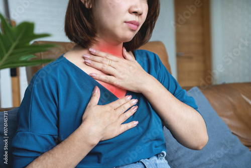 Asian woman suffering from gastroesophageal reflux disease feeling sore throat and heartburn