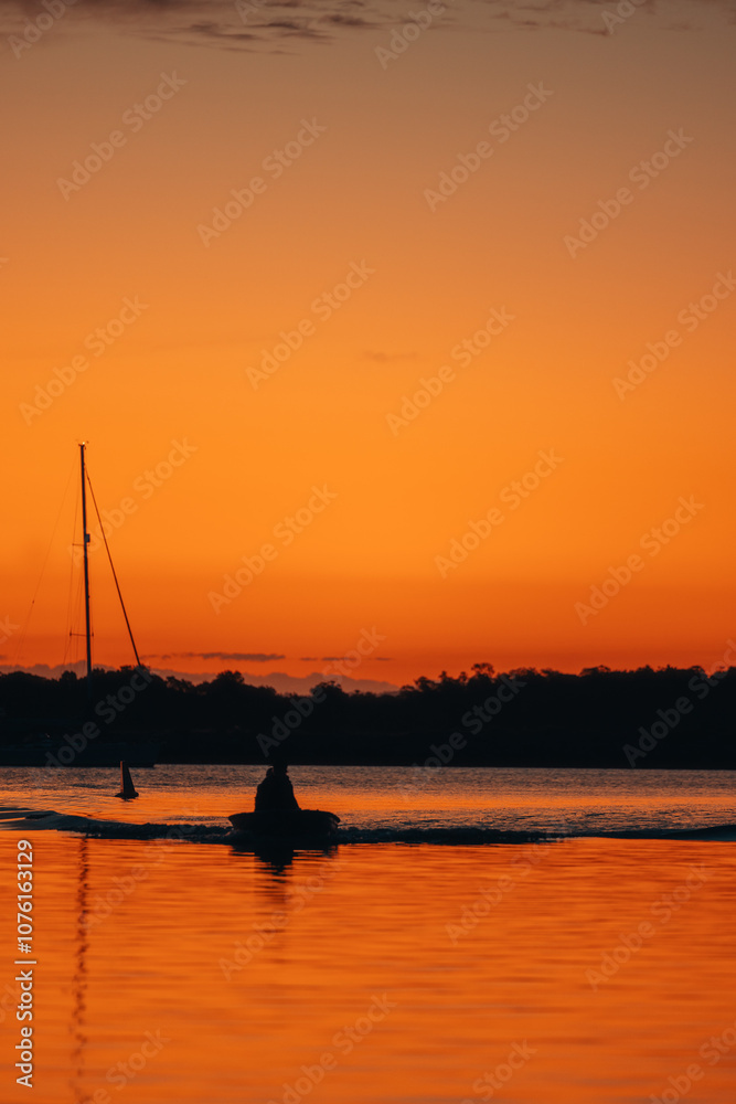 Silhouette image of two people in small dinghy on the Clarence River at sunset Silhouette image of two people in small dinghy on the Clarence River at sunset