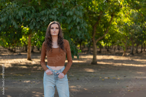 Women standing in front of dense orchard full of trees on a farm