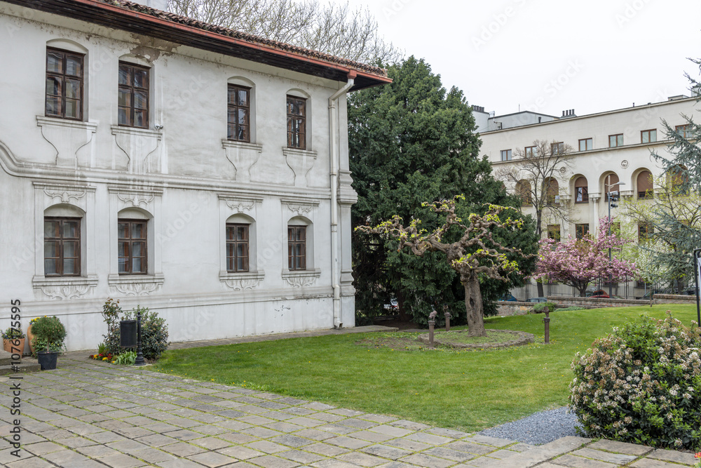 Fototapeta premium White building with a red roof and a courtyard in front of it