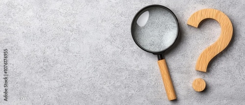 Magnifying Glass and Wooden Question Mark on Grey Background, Seeking Answers and Solutions photo