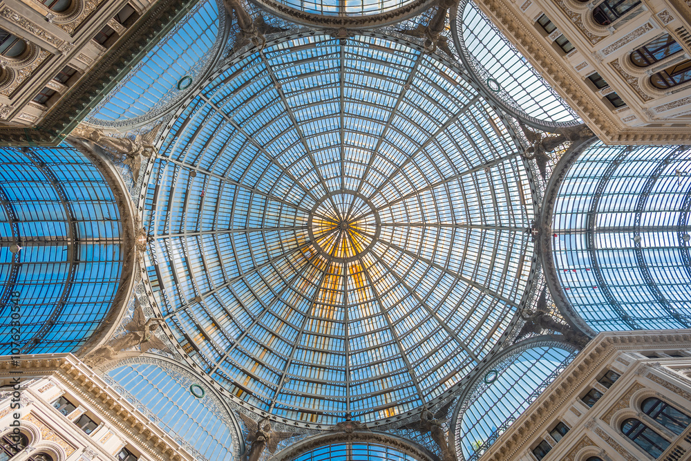 Majestic metal structure with glass windows of galleria umberto I in naples, italy. Beautiful old building with glass ceiling and multitude of shops inside. Looking directly up