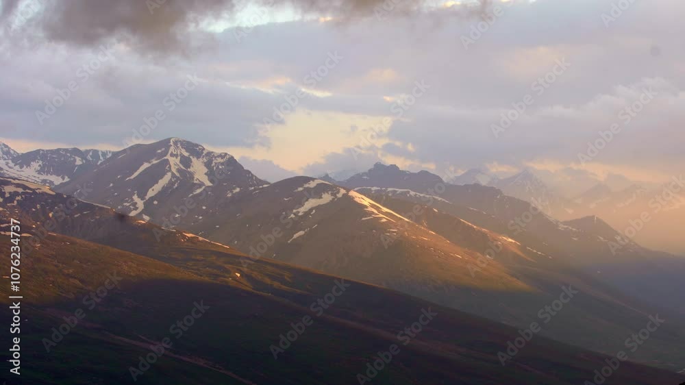 Stunning view of mountains, snow on top, in a beautiful sunlight and some fog, cloudy sky, static and copy space Stunning view of mountains, snow on top, in a beautiful sunlight and some fog, cloudy sky, static and copy space