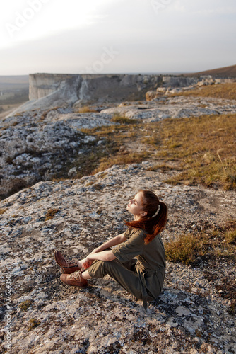 Wallpaper Mural Woman sitting on rock in field gazing at sky in serene moment of tranquility and meditation Torontodigital.ca