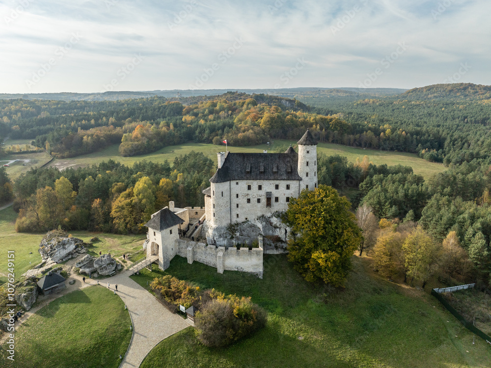 Obraz premium Aerial drone view of Bobolice Castle in autumn.Old medieval fortress, royal castle in the village of Bobolice, Poland.Strongholds Eagles Nests in Polish Jurassic Highland.Limestone rock castle ruins.
