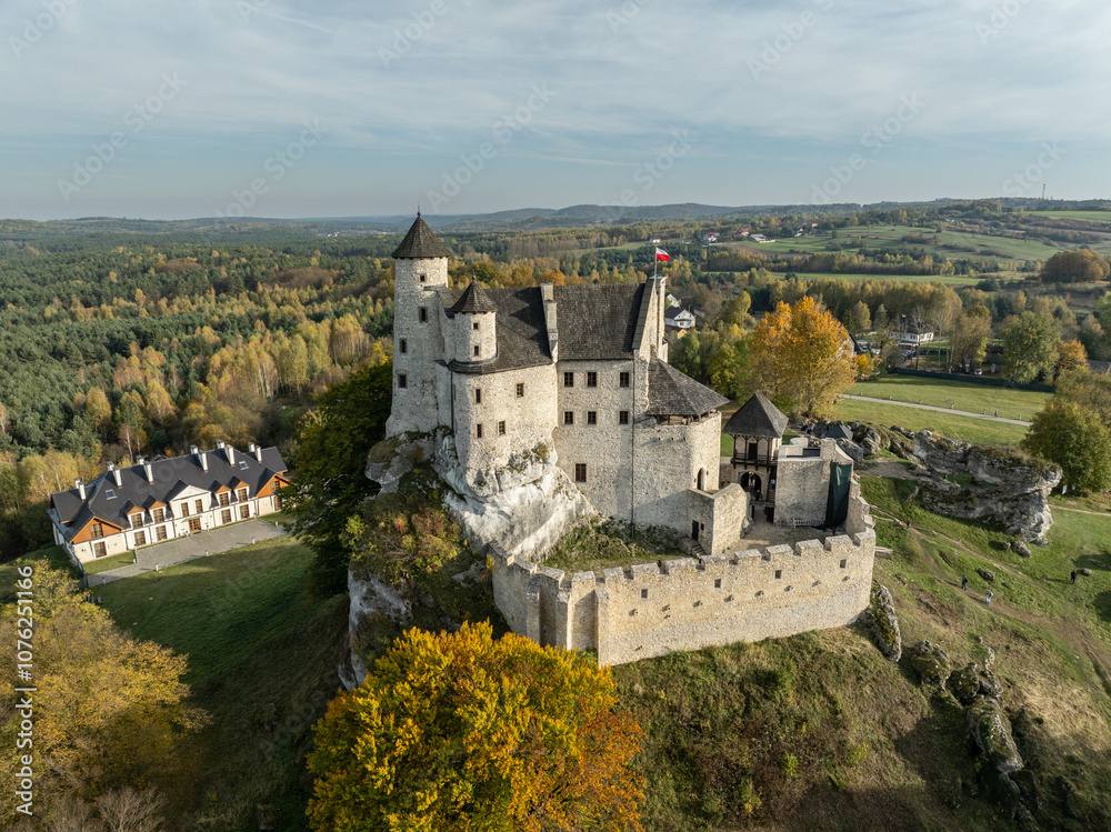 Obraz premium Aerial drone view of Bobolice Castle in autumn.Old medieval fortress, royal castle in the village of Bobolice, Poland.Strongholds Eagles Nests in Polish Jurassic Highland.Limestone rock castle ruins.