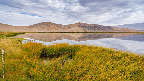 Scenic rural landscape view of Bulunkul lake with colorful mountains reflection, Murghab, Gorno-Badakhshan, Tajikistan photo