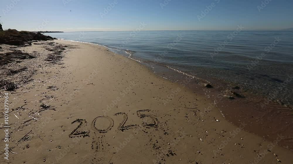 New Year 2025, lettering on the beach with wave and clear blue sea. Numbers 2025 year on the sea shore, message handwritten in the golden sand on beautiful beach background. New Years concept. New Year 2025, lettering on the beach with wave and clear blue sea. Numbers 2025 year on the sea shore, message handwritten in the golden sand on beautiful beach background. New Years concept.