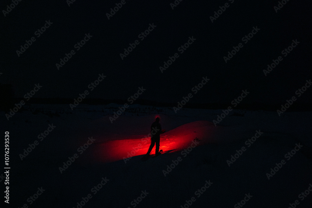 A Person in the Snow Shining a Creepy Red Flashlight in the Dark Night