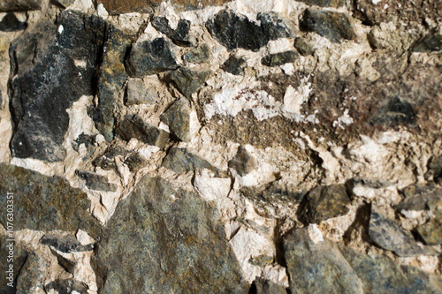 Rough textured closeup of rocky stone wall. Stony natural stone texture. Grunge background.