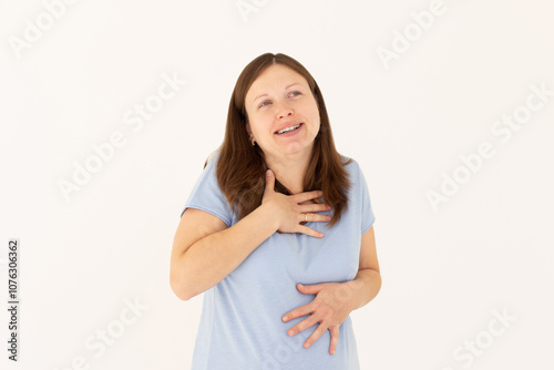 Portrait of extremely happy girl in blue t-shirt holding her stomach and chest and laughing out loud, chuckling giggling at amusing anecdote, sincere emotion. isolated on white background