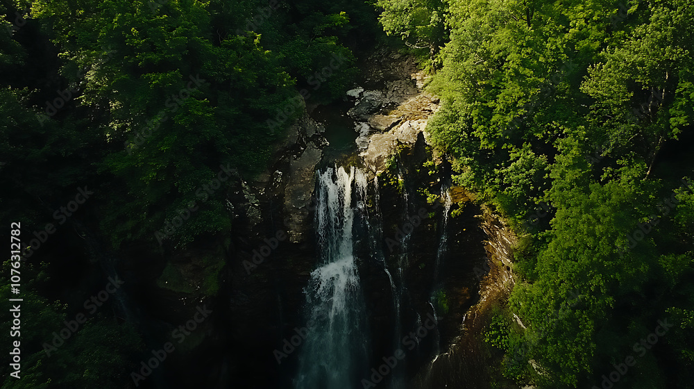 An aerial view of a secluded waterfall surrounded by dense foliage, showcasing the beauty of untouched nature An aerial view of a secluded waterfall surrounded by dense foliage, showcasing the beauty of untouched nature