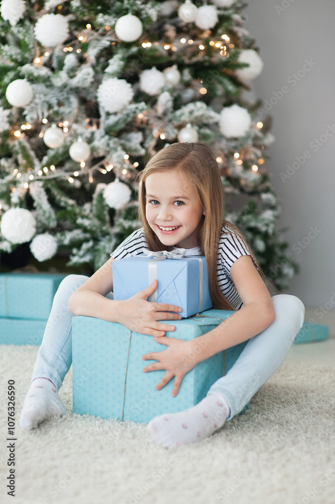 Happy little girl with gift box near Christmas tree, winter holiday and xmas time concept Happy little girl with gift box near Christmas tree, winter holiday and xmas time concept