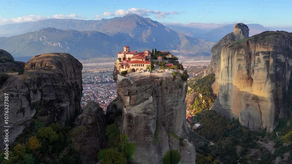 Aerial sunrise view view of Meteora mountains with Agi Triada monastery situaded on a cliff high over the city of Kalabaka, Greece Aerial sunrise view view of Meteora mountains with Agi Triada monastery situaded on a cliff high over the city of Kalabaka, Greece