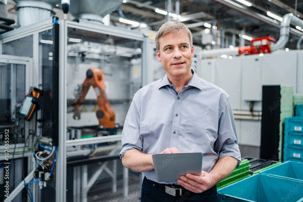 Businessman using digital tablet on shop floor in a factory Businessman using digital tablet on shop floor in a factory