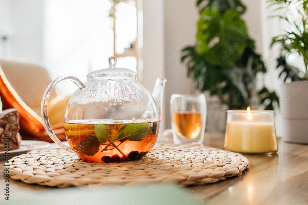 Herbal tea with mint leaves and autumn berries near candle on table Herbal tea with mint leaves and autumn berries near candle on table