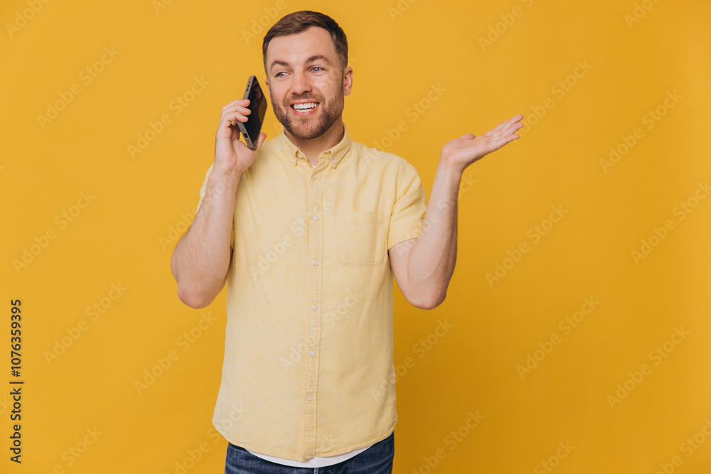 Handsome attractive smiling guy millennial hold phone and show copy space, popular blogger addicted user wear casual yellow shirt isolated yellow color Handsome attractive smiling guy millennial hold phone and show copy space, popular blogger addicted user wear casual yellow shirt isolated yellow color