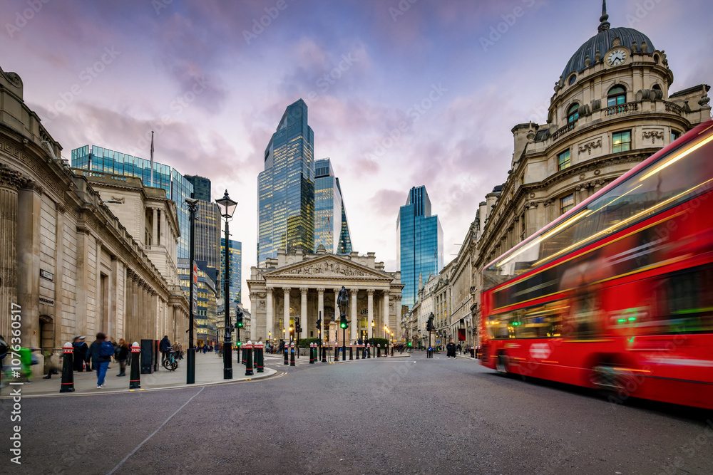 Sunset view of the City of London, England, with commuter and street traffic in front of the Bank of England