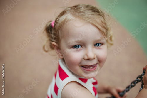 Portrait of little toddler girl having fun at playground photo