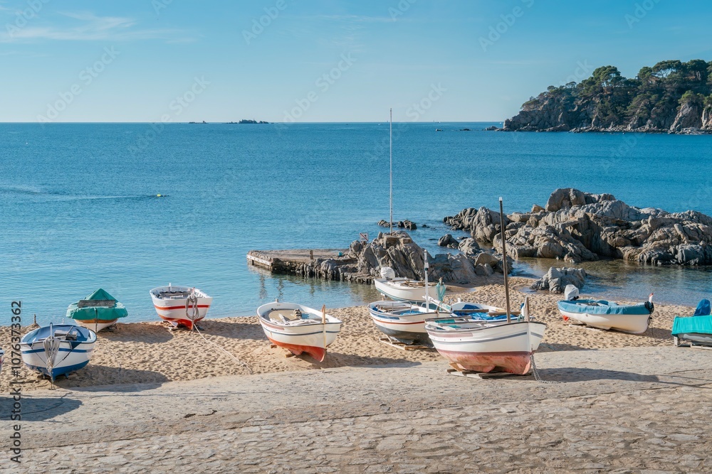 Traditional Mediterranean Fishing Boats on Sandy Beach with White Village Backdrop. Calella de Palafrugell, Where Authentic Costa Brava Maritime Heritage Meets Charming Coastal Architecture