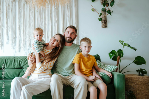 Portrait of family with two sons sitting on the couch in living room photo