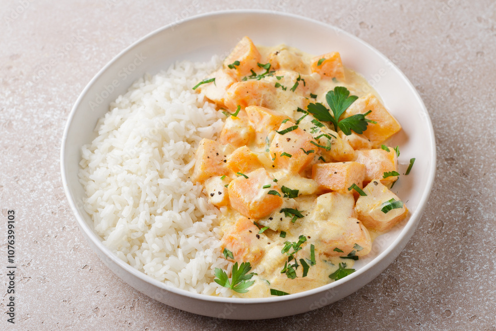 Bowl of pumpkin in sour cream sauce with rice sprinkled with fresh parsley on beige textured stone table, top view. Vegetarian food Bowl of pumpkin in sour cream sauce with rice sprinkled with fresh parsley on beige textured stone table, top view. Vegetarian food