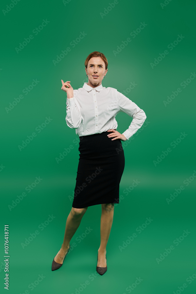 A poised woman in a stylish white shirt shows confidence while standing against a vibrant green background. A poised woman in a stylish white shirt shows confidence while standing against a vibrant green background.