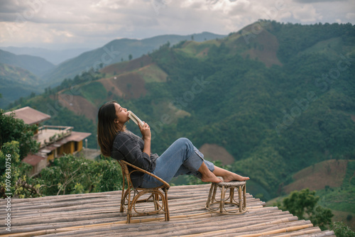 woman reading a book and sitting on a bench in the mountains view