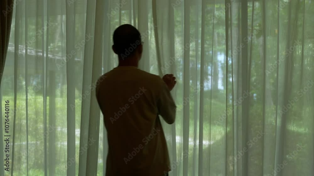 POV to an asian man while walking to open white Transparent Curtains in living room bedroom while traveling taking holiday vacation with outside view of natural green tropical landscape