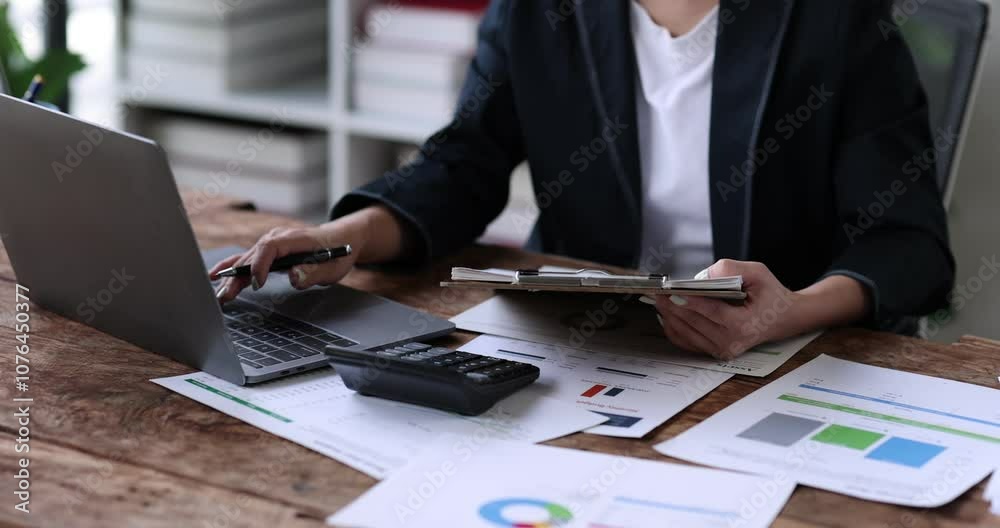 Business financing accounting banking concept. Business woman hand doing finances and calculate on desk about cost at home office. Woman working on desk with using calculator, finance accounting.
