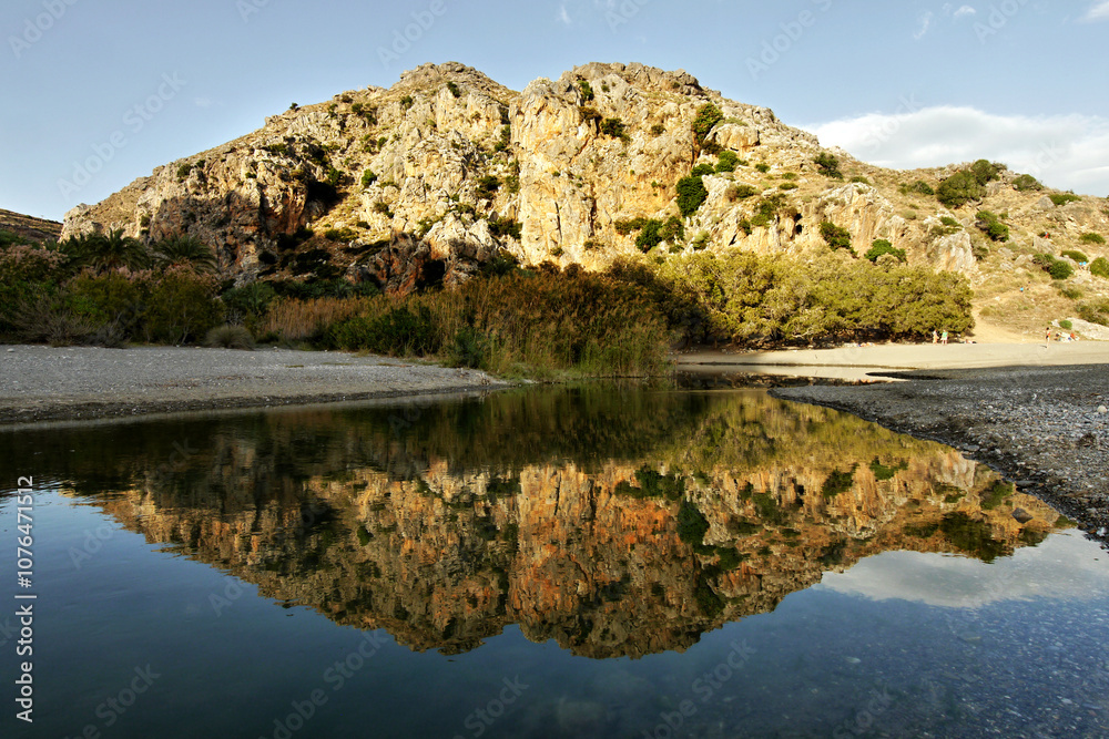 Fototapeta premium Rock reflection in the water in the evening light on the coast in Greece