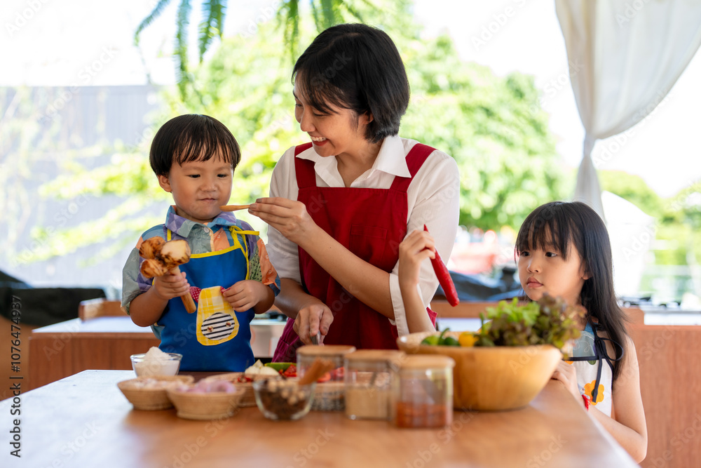 Fototapeta premium Asian family cooking together in kitchen at home