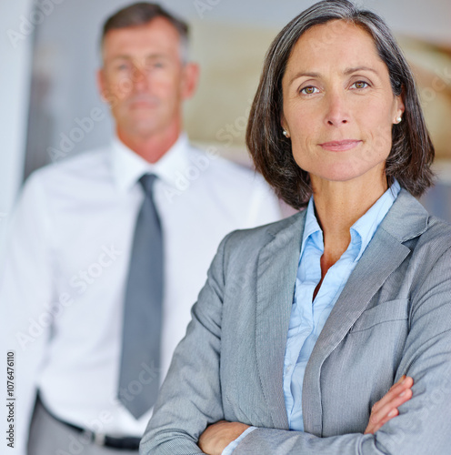 Arms crossed, business and portrait of mature woman in office with colleague for company management. Corporate, leadership and suit with confident or proud manager person in professional workplace