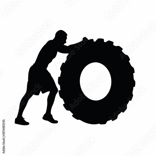 A man is pushing a tire. The tire is black and white. The man is wearing shorts