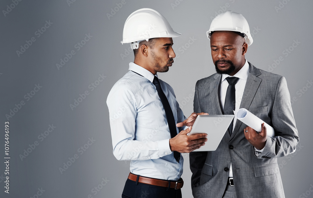 People, architect and talking with tablet in studio for construction, research and renovation schedule. Men, mockup space and online design, blueprint and floor plan of maintenance on gray background People, architect and talking with tablet in studio for construction, research and renovation schedule. Men, mockup space and online design, blueprint and floor plan of maintenance on gray background