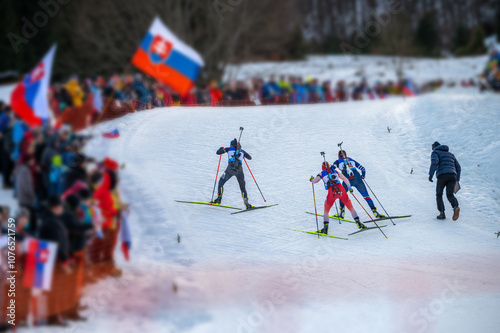 Biathlon race, female athletes climbs a hill. Winter sport, nordic ski race