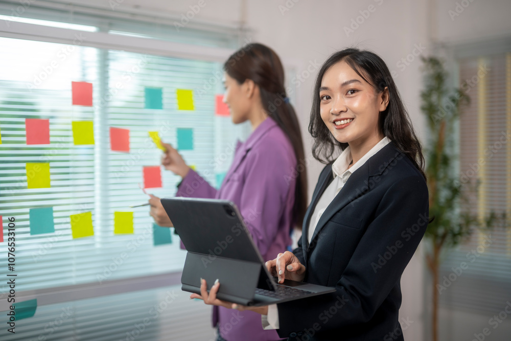 Two women in business attire are working on a project together Two women in business attire are working on a project together