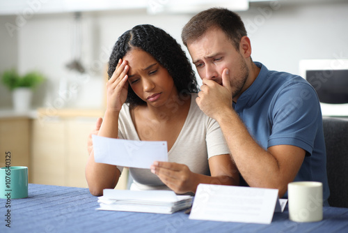 Obraz na płótnie Worried interracial couple complaining reading invoice