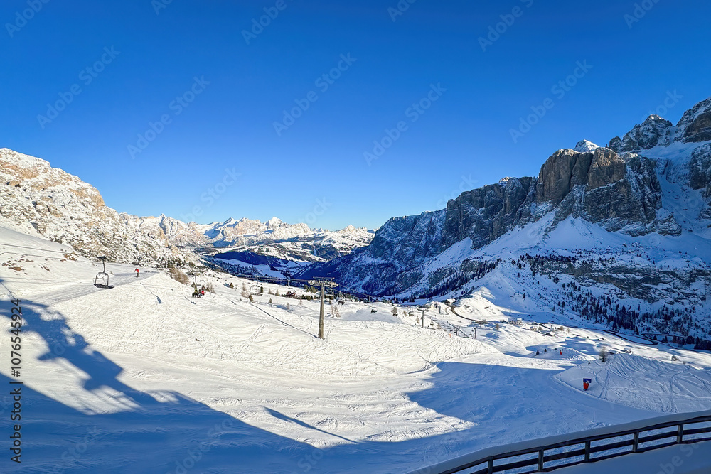 Scenic view from Gardena Pass to Kufar Alta Badia and mountains of the Fanes Group e.g. Cuntrines, Lagazuoi, Tofana di Rozes in winter against blue sky