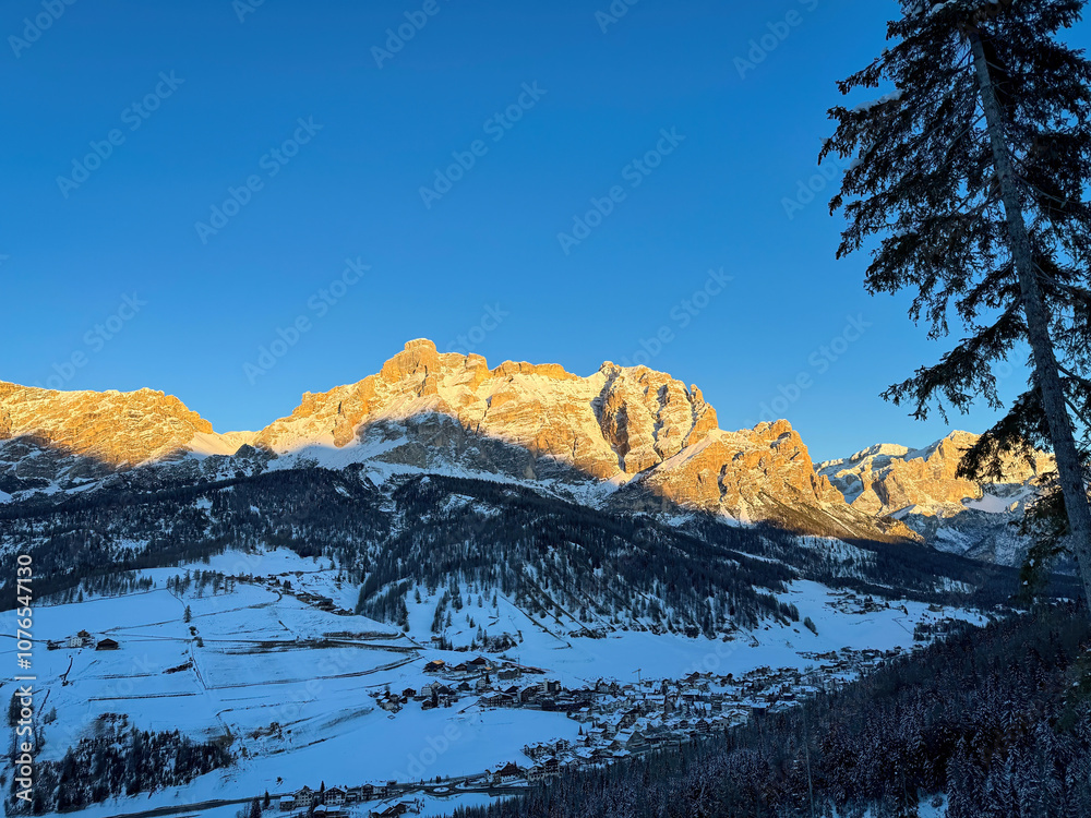 Scenic view of St. Kassian with Piz Lavarela (links) and Piz Cunturines (right) in the Dolomites, South Tyrol, Italy in winter at sunset against blue sky