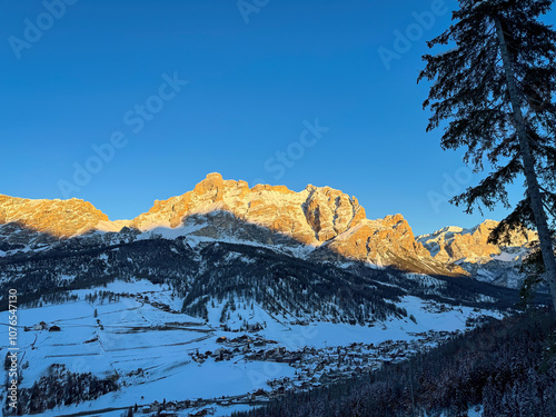 Obraz na płótnie Scenic view of St. Kassian with Piz Lavarela (links) and Piz Cunturines (right) in the Dolomites, South Tyrol, Italy in winter at sunset against blue sky w salonie