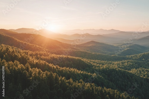 Mountain range with fore at sunset, with the sun setting behind them.  photo