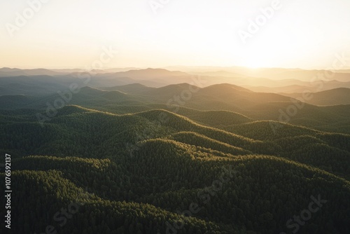 Mountain range with fore at sunset, with the sun setting behind them. 