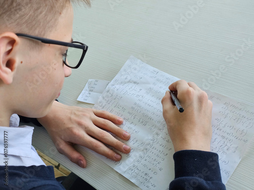 A school student cheats on a test using an answer sheet concept photo