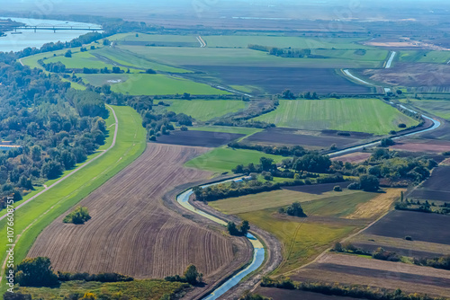 Aerial view of valley with farm fields, pond and Danube river. High quality photo